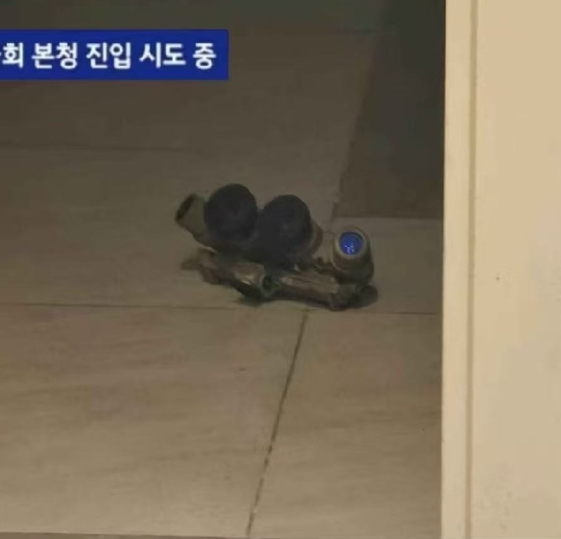 A set of night-vision goggles and a gun lies on a tiled floor in a building. (Captioned by AI)