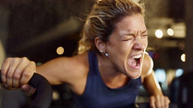 close up portrait of woman yelling while working out on an elliptical
